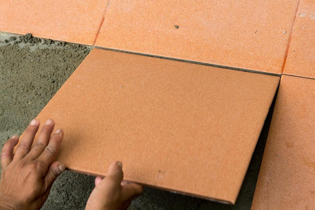 professional tiler working on external tiling 