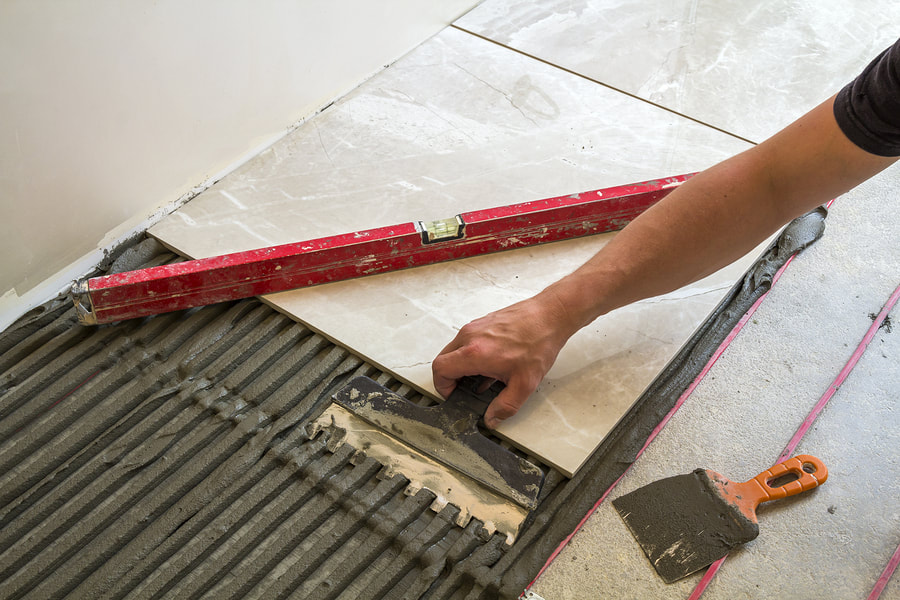 professional tiler working on floor tiling 